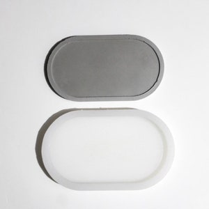 May include: A gray oval-shaped tray with a white silicone mold. The mold is slightly larger than the tray.
