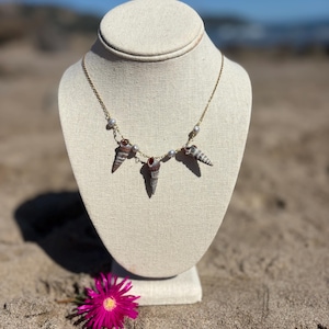 May include: A set of three ceramic mugs with a speckled, matte finish in cream, light grey, and dark grey. Each mug has a simple, minimalist design and a rounded handle.