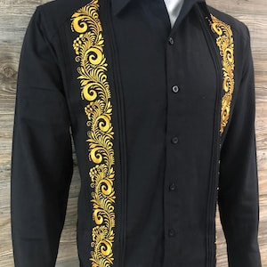May include: A black long-sleeve button-up shirt with gold embroidery on the front. The embroidery features a floral design.