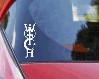 May include: A red car with a white sticker on the back window. The sticker features a stylized design with a crown, cross, and crescent moon.