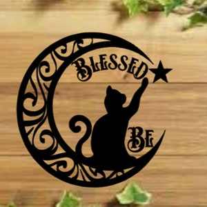 May include: Black silhouette of a cat reaching for a star on a crescent moon with the words "Blessed Be" in a decorative font.
