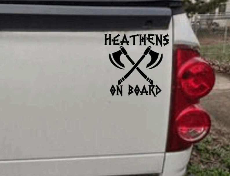 May include: Black and white sticker with the text "HEATHENS ON BOARD" and a graphic of two crossed axes.