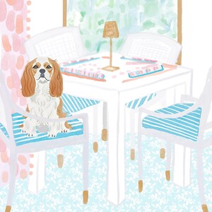 Puede incluir: Ilustraci&oacute;n en acuarela de un Cavalier King Charles Spaniel sentado en una silla con cojines a rayas azules y blancas. La escena incluye una mesa blanca, sillas y una peque&ntilde;a l&aacute;mpara. El fondo presenta una ventana y cortinas estampadas.