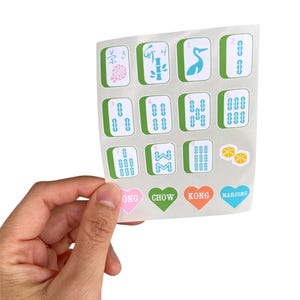 K&ouml;nnte beinhalten: Ein Bogen mit Mahjong-Fliesen-Aufklebern. Die Aufkleber zeigen verschiedene Fliesen mit Symbolen und Zahlen sowie herzf&ouml;rmige Aufkleber mit den W&ouml;rtern "ONG", "CHOW", "KONG" und "MAHJONG". Die Fliesen sind gr&uuml;n und wei&szlig;.