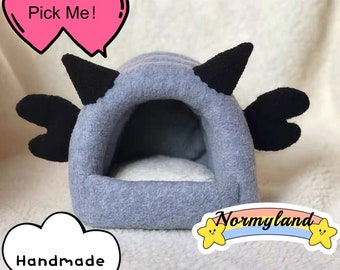 May include: A gray and black fleece pet bed shaped like a cartoon character with the text "Pick Me!" and "Handmade" on the image. The bed has a small opening for a pet to enter.