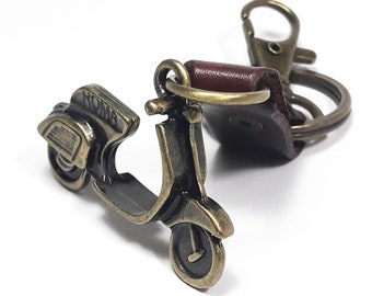 Llavero Vespa 3D: dije de scooter en tono latón con etiqueta de cuero.