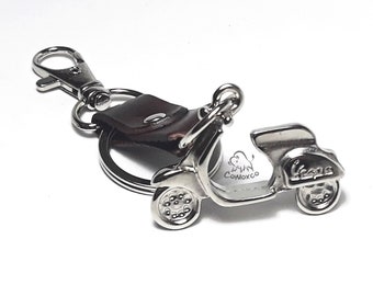 Llavero Vespa 3D: Llavero de scooter en tono latón con etiqueta de cuero.