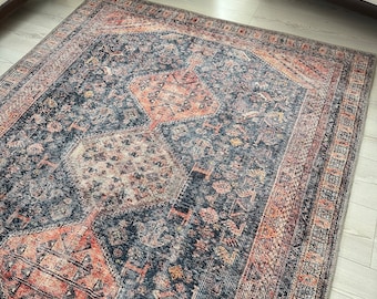May include: A vintage-style rug with a dark blue background and intricate patterns in shades of orange, pink, and yellow.