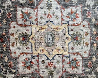 May include: A gray rug with a traditional Persian design. The rug features intricate patterns in shades of red, blue, and yellow.