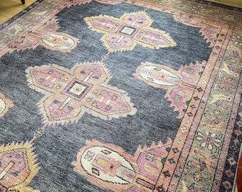 May include: A vintage rug with a dark blue background and intricate floral patterns in shades of pink, yellow, and beige. The rug has a fringed edge and a traditional design.