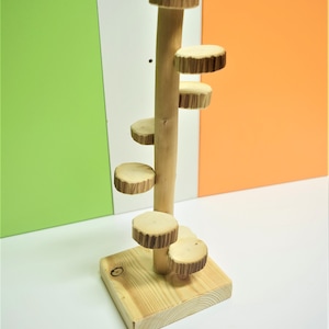 Könnte beinhalten: Ein Holzspielzeug mit einer Wendeltreppe für kleine Tiere. Das Spielzeug ist aus Naturholz gefertigt und hat eine hellbraune Farbe.