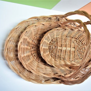 Pu&ograve; includere: Un set di tre cesti in vimini intrecciato con manici. I cesti sono annidati l'uno dentro l'altro, con il cestello pi&ugrave; grande in basso e il cestello pi&ugrave; piccolo in alto.