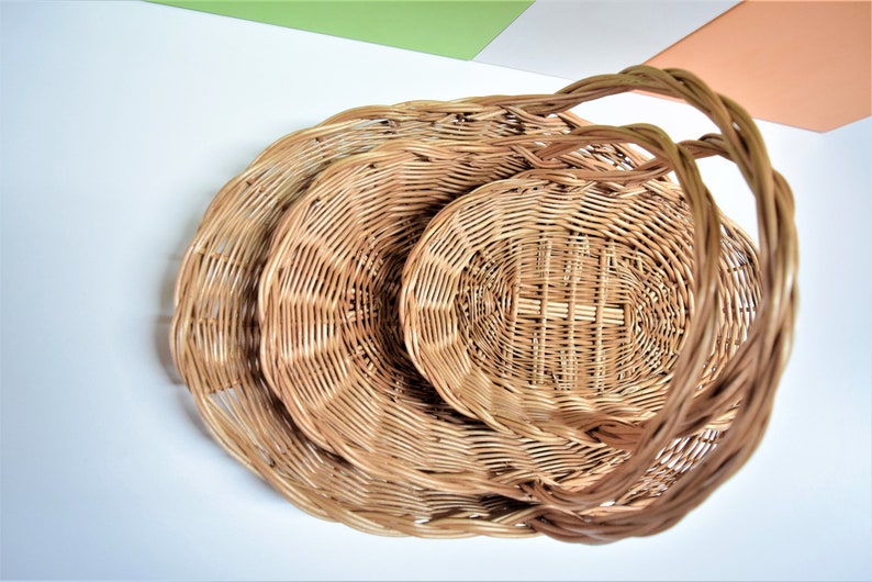 Pu&ograve; includere: Un set di tre cesti in vimini intrecciato con manici. I cesti sono annidati l'uno dentro l'altro, con il cestello pi&ugrave; grande in basso e il cestello pi&ugrave; piccolo in alto.