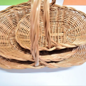 Pu&ograve; includere: Un set di tre cesti ovali in vimini con manici. I cesti sono annidati l'uno dentro l'altro, con il cestello pi&ugrave; grande in basso e il cestello pi&ugrave; piccolo in alto.