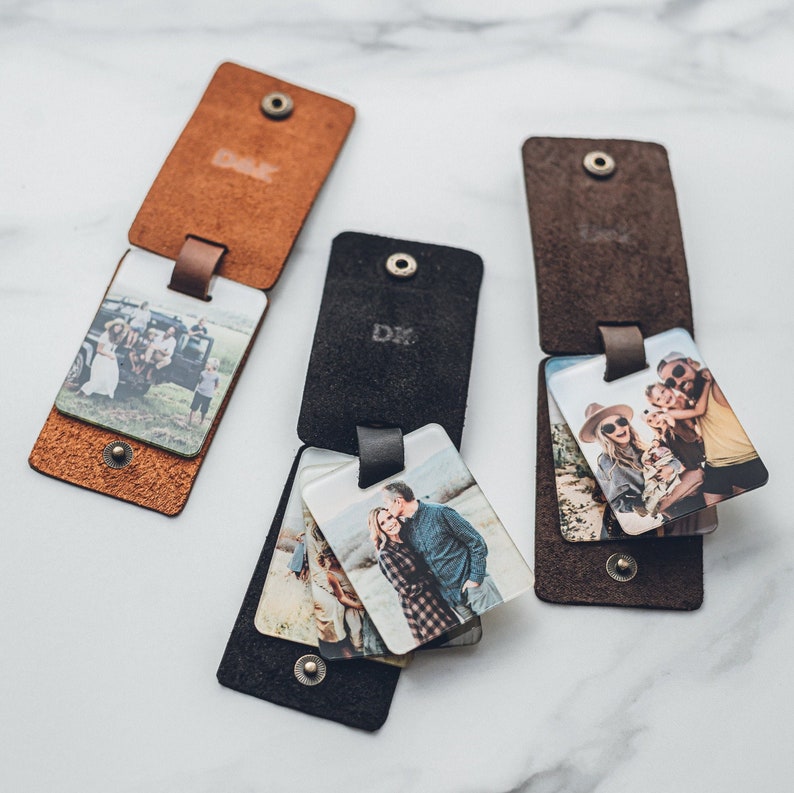 Three different colored leather keychains with photos inside