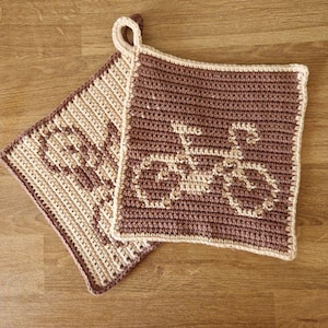 May include: Two crocheted pot holders, one brown with a white bicycle design and one beige with a brown design.