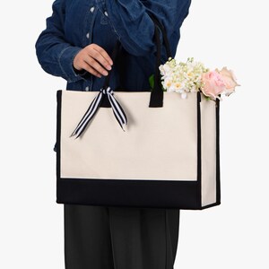 a woman holding a white and black bag