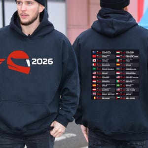 May include: Navy blue hooded sweatshirt with a red helmet graphic and the number "2026" on the front. The back of the sweatshirt displays a list of race locations with flags.