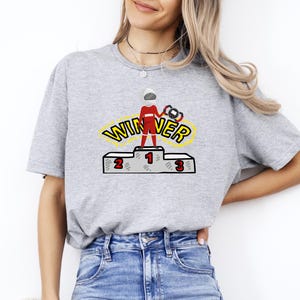 Camiseta de mujer con podio de ganadores • Camiseta gráfica de campeón de carreras • Camiseta con podio de trofeos