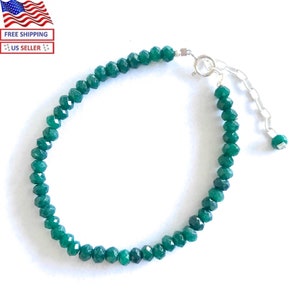 May include: A green gemstone bracelet with a silver clasp and extender chain. The bracelet is made of faceted beads.