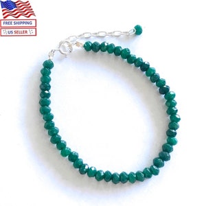 Pode incluir: Uma caneca de cerâmica branca com uma alça preta e o texto "But First, Coffee" em negrito preto. A caneca está sobre uma superfície branca, mostrando seu design limpo.