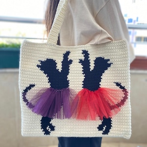 May include: A white crocheted tote bag with black silhouettes of two dogs wearing purple and red tulle tutus.