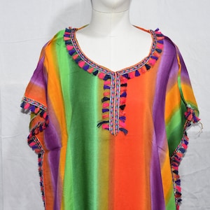 May include: A colorful striped kaftan with a V-neckline and tassel trim. The kaftan is made of a lightweight fabric and has a relaxed fit.