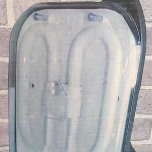 May include: A black and white fluorescent light fixture with a handle. The light fixture is in a clear plastic casing.