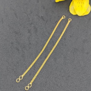 May include: Two gold chain extenders with a loop at each end. The extenders are about 6 inches long.