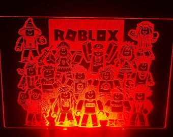 May include: A red light-up sign with the word "ROBLOX" in white letters and a group of cartoon characters in a variety of poses. The characters are all wearing different outfits and accessories.