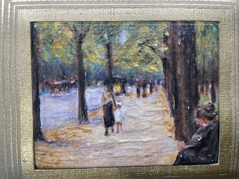 May include: An impressionistic painting of a tree-lined path with figures, a horse-drawn carriage, and a woman seated on the right. The artwork is framed in a gold-colored frame, enhancing the vintage aesthetic.
