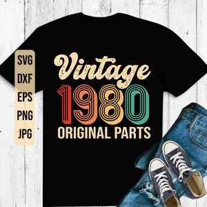 May include: Black t-shirt with a vintage 1980 design in rainbow colors. The text "Vintage 1980 Original Parts" is printed on the shirt.
