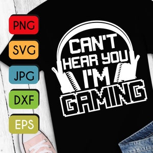 Può includere: Una maglietta nera con un design grafico bianco di una persona che indossa le cuffie con il testo "Can't hear you I'm gaming".