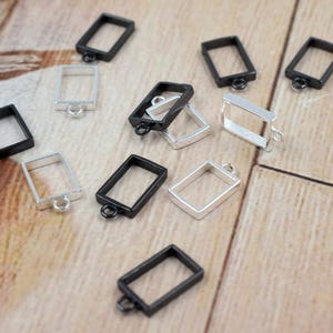 Open brass rectangle bezel charm on hand for size reference