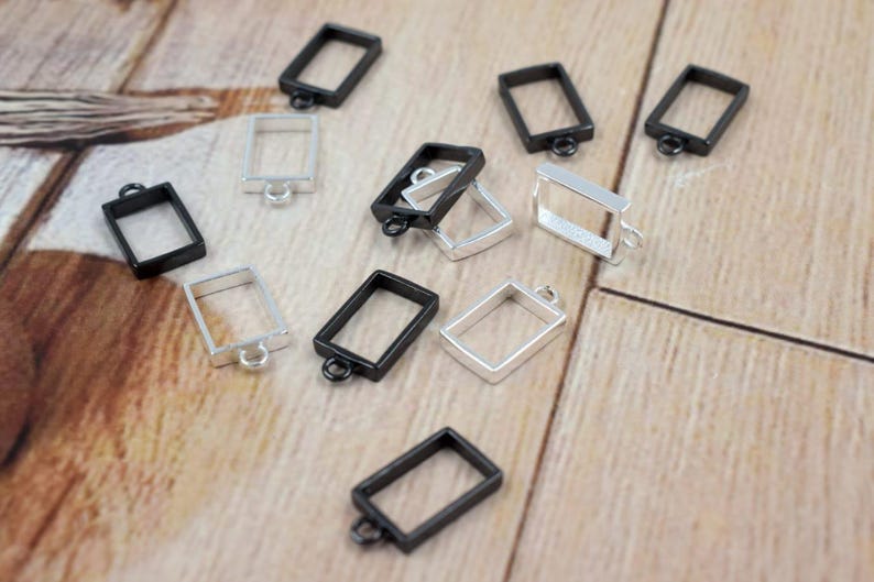 Open brass rectangle bezel charm on hand for size reference
