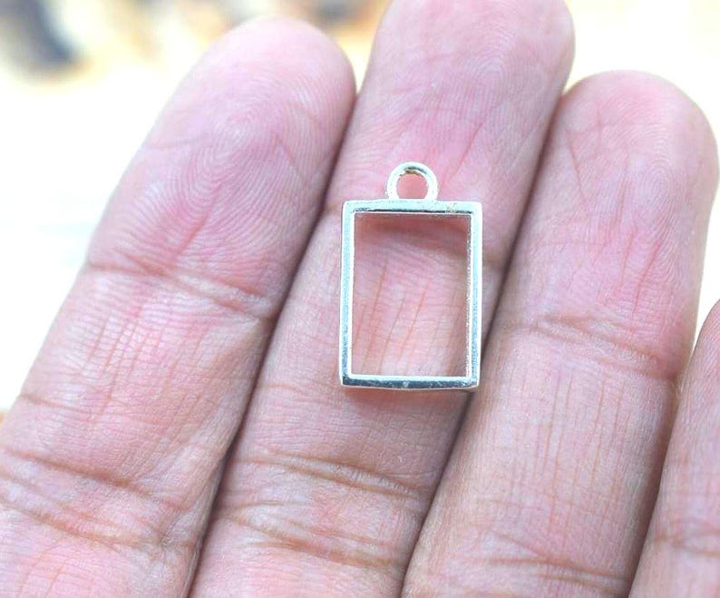 10x14mm rectangular brass open bezel frame pendant with loop, 3.25mm deep, shown on hand for size reference