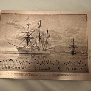 Op de afbeelding: Vintage sepia-getinte advertentie met een groot zeilschip op het water, met kleinere schepen op de achtergrond. De tekst "BEECHAMS PILLS 3 BOXES" staat onderaan afgedrukt, samen met figuren die vlaggen vasthouden.