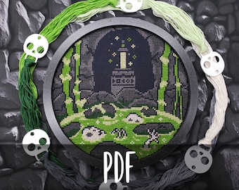 May include: A black and green cross-stitch pattern in a round embroidery hoop, depicting a dark cave with a glowing light source and a green swamp in the foreground. The text "PDF" is printed below the hoop.