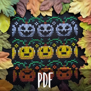 Peut inclure: Un motif de point de croix sur tissu noir représentant trois rangées horizontales de citrouilles d'Halloween aux dégradés bleu, jaune et orange avec des détails de vignes vertes et de petites étoiles. Le mot PDF est imprimé en blanc au centre.