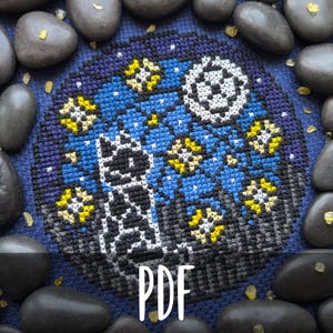 Può includere: Un disegno a punto croce con la sagoma di un gatto sotto un cielo stellato con una luna a mezzaluna. Il disegno è circondato da pietre grigio scuro e la parola "PDF". La tavolozza dei colori comprende blu, gialli e bianchi.