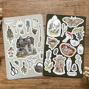 May include: Two sheets of stickers featuring illustrations of a cottage, mushrooms, a bird in a cage, a butterfly, a nest, and other nature-themed elements. The stickers are on a white background with a green border. The text "THORAIN Art & Illustration" is printed on the bottom of each sheet.