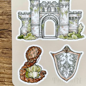 May include: A set of stickers featuring a stone castle with a large archway, a woman with long braided hair, and a silver shield with ornate designs.