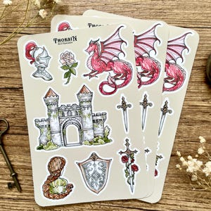 May include: Three sheets of stickers featuring a red dragon, a castle, a sword with roses, a shield, a knight's helmet, a rose, and a woman with long hair. The stickers are on a beige background and have the text "THORAIN Art & Illustration" on them.