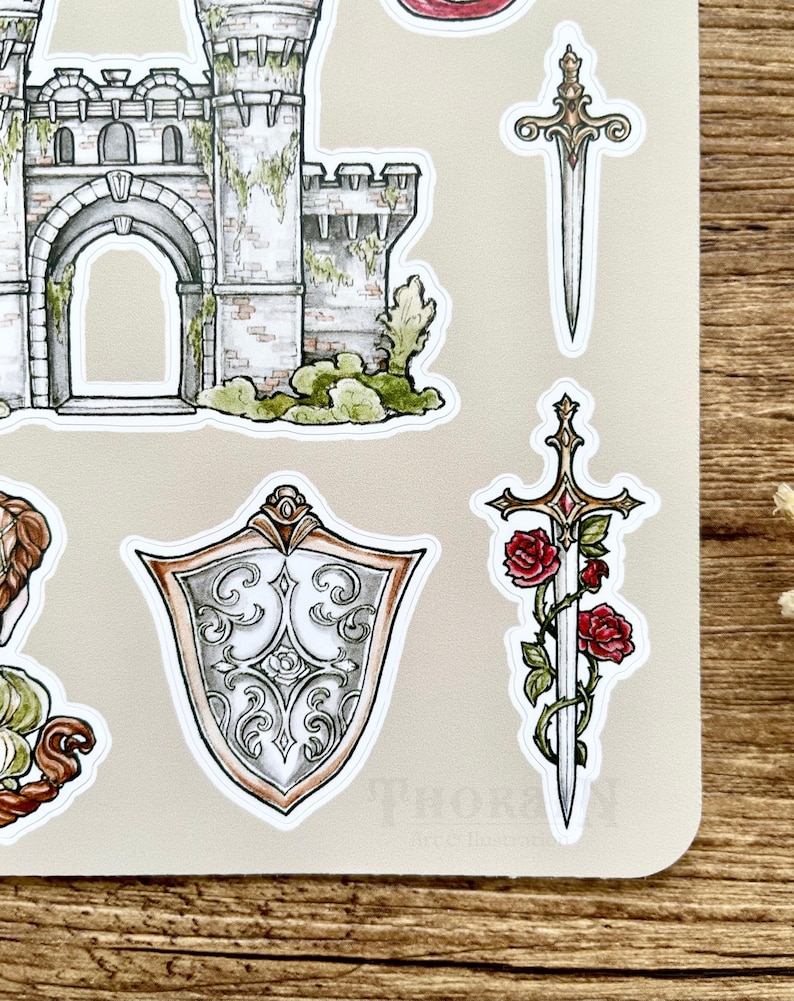 May include: A set of five stickers featuring a castle, two swords, and a shield. The castle is gray and green with a stone archway. The swords are silver with gold accents. The shield is silver with a decorative design. The stickers are on a beige background.
