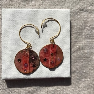 Boucles d’oreilles pendantes rondes asymétriques sur crochets créoles ouverts. Aquarelle sur carton, pierres collées  «Ciel étoilé terreux»