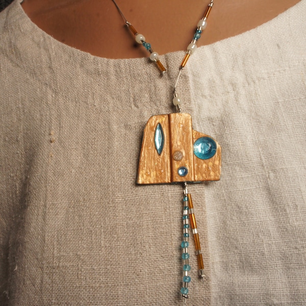 Collier et pendentif à pierres strass bleues monté sur cable acier orné de perles nacrées, camel et bleues «Extra-terrestre aux yeux bleus»