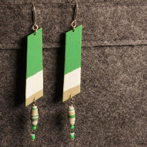 May include: A pair of green, white, and gold dangle earrings with green and white bead accents.
