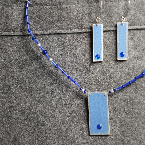 Collier de perles bleues et argentées court à pendentif rectangulaire monté sur fil de nylon avec fermoir à vis  "Collier à œil bleu"