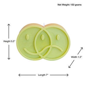 Puede incluir: Una vela verde lima con forma de dos caras sonrientes superpuestas, una feliz y otra triste. La vela mide 17,8 cm de largo, 14 cm de alto y 3,8 cm de ancho. Peso neto: 150 gramos.