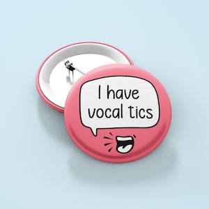 May include: Pink button with a white speech bubble that says "I have vocal tics". The speech bubble has a cartoon mouth with a tongue sticking out.